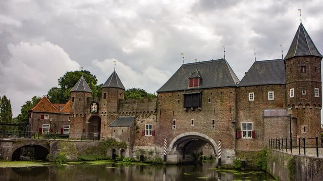 Bikes and pedestrians passing an old medieval city gate, the Netherlands, 4K time lapse