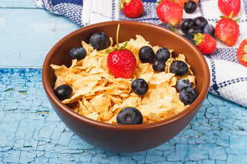 Portion of corn flakes in the bowl with blueberries
