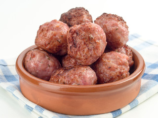 fried meatballs in clay pot, isolated