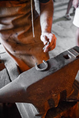 The blacksmith forging glowing horseshoe