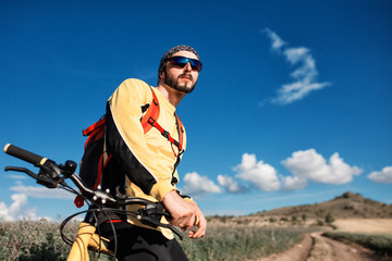 Fototapeta premium Mountain Bike cyclist riding single track above sunset valley