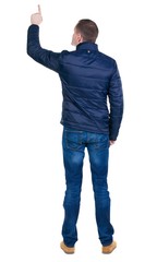 Back view of  pointing young men in  jacket and jeans. Young guy  gesture. Rear view people collection.  backside view of person.  Isolated over white background.
