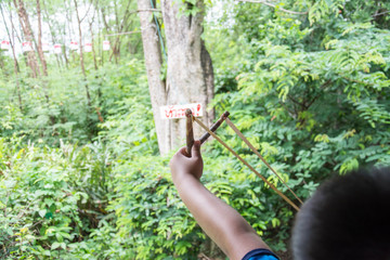  Young Boy Holding Sling Shot, Pulling Rubber Strips Back in Anticipation of Catapult Shot 