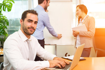 Young attractive businessman working at the office with associat