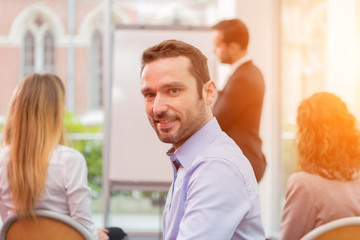 Young attractive businessman working at the office with associat