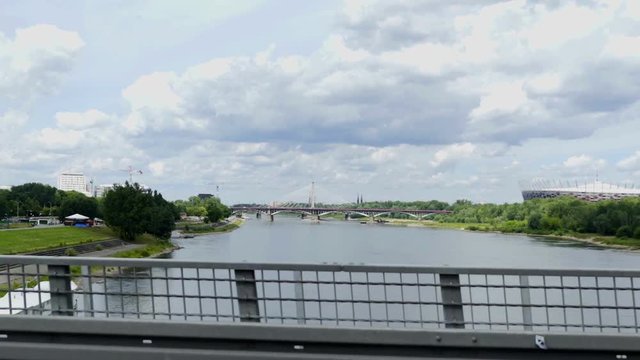 POLAND 2016: A car is driving on a bridge over Visla from one side of the city to another. We can see water underneath. Wide-angle shot.
