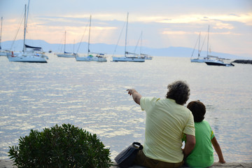 Father and son showing him the sea and yachts