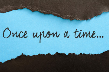torn blue and black paper background. Phrase once upon a time on the torn paper © MarkoVS87