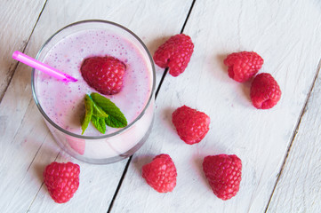 Glass of milkshake with fresh raspberries