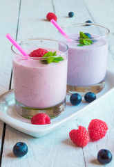 Two glasses of milkshake with fresh berries