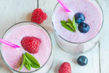 Two glasses of milkshake with fresh berries