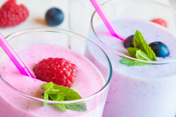 Two glasses of milkshake with fresh berries