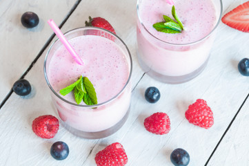 Two glasses of milkshake with fresh berries