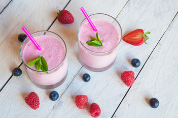 Two glasses of milkshake with fresh berries