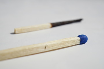 Isolated background with unburnt and burnt safety matches as a symbol of contrast, choice or progression 