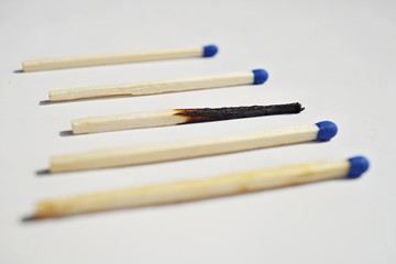 Isolated background with unburnt and burnt safety matches as a symbol of contrast, choice or progression 