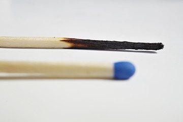 Isolated background with unburnt and burnt safety matches as a symbol of contrast, choice or progression 