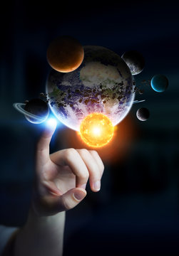 Businesswoman touching solar system with his fingers