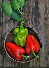 fresh peppers in old wooden utensils. side view. vertical photo for the kitchen. background blur