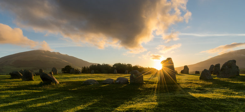 Majestic sunrise at Castlerigg Stone Circle in the Lake District with beautiful shadows and sunburst.