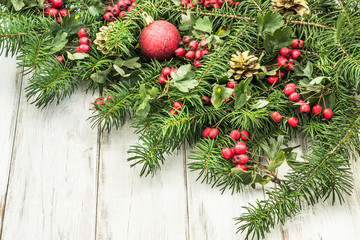 Ornamental christmas tree branch on wooden background