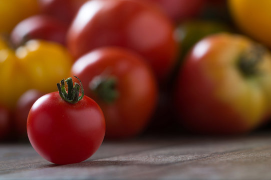 Colorful tomatoes on rustic wooden background. Shallow depth of field. Copy space