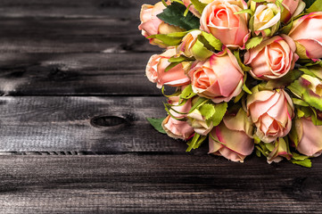 Pink roses on wooden background