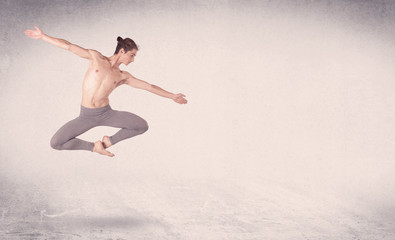 Modern ballet dancer performing art jump with empty background