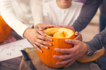 Family carving pumpkin for Halloween, close up
