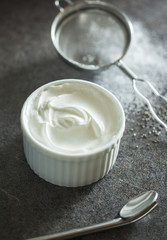 Sour cream with strainer and spoon