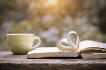 Pages of a book curved into a heart shape.heart of the book.coffee background,old book page decorate to heart shape for love in valentine day.