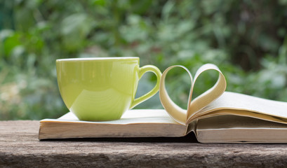 Pages of a book curved into a heart shape.heart of the book.coffee background,old book page decorate to heart shape for love in valentine day.