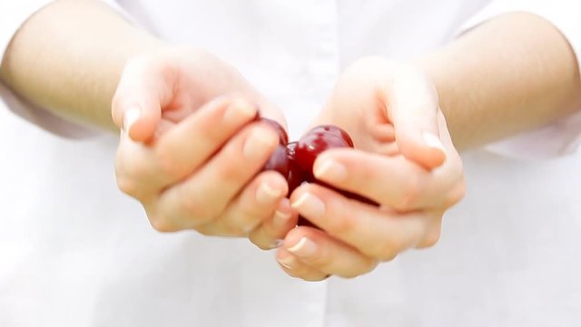 Woman holding a handful of cherries