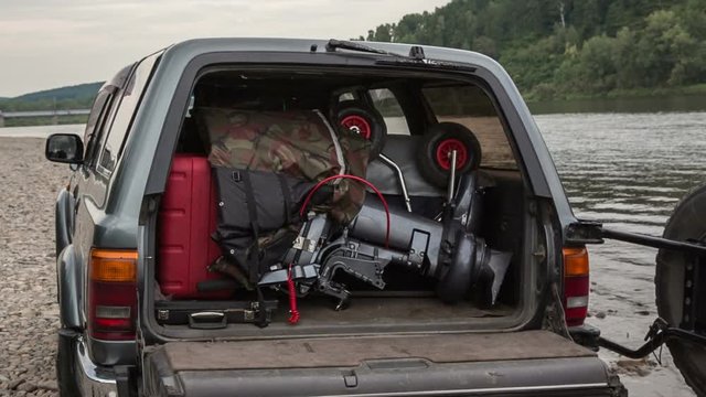 pvc boat with outboard engine is packed in the car trunk