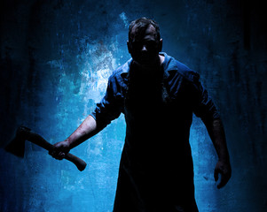 Fototapeta na wymiar Bloody Halloween theme: crazy killer as butcher with an ax