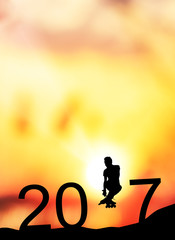 silhouette man jumps to make the word Happy New Year 2017 with sunrise.