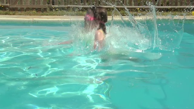 Young Girl Jumping Into Outdoor Pool In Slow Motion