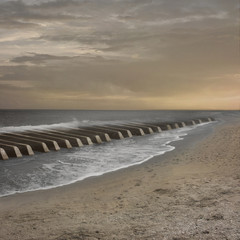 The beach looks like keys of a piano. Sea waves make music on the them.