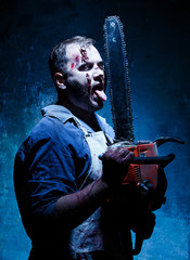 Bloody Halloween theme: crazy killer as butcher with electric saw