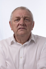 Close up portrait image of a mature man looking annoyed. Taken on a white background. 