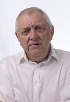 Close up portrait image of a mature man looking confused. Taken on a white background 