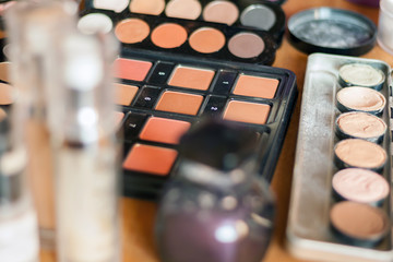 Blurry professional visagiste workspace. Makeup tools. Creative mess