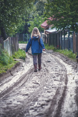 Fototapeta na wymiar Curly Girl Walks on Dirty Road