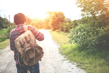 Back portrait of Young man traveler with backpack travel concept