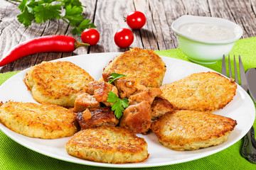 potatoes pancakes with stewed pork meat. close-up