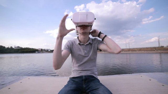 Man Wearing VR Headset ina city. Using Gestures with Hands. HD.