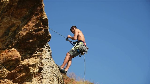 Extreme Climber Descends A Rope From A Cliff. Slow Motion Effect