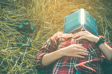 hipster man lying down on grassland napping tired after reading