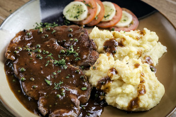 beef steak meal with mashed potato and gravy sauce