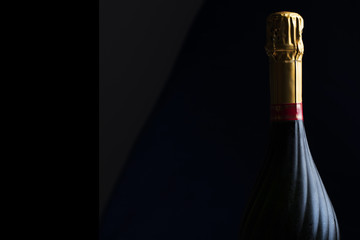 Champagne bottle on a black background with space for text